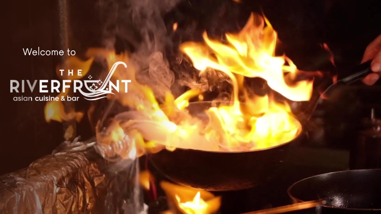 A cook working over a flame in The Riverfront kitchen